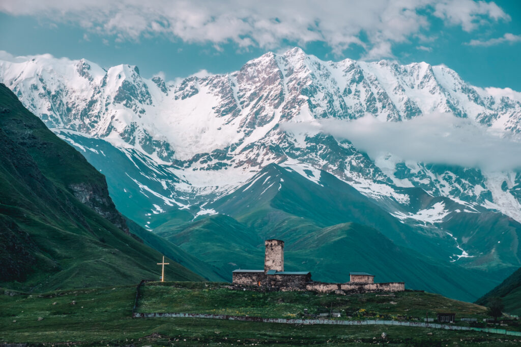 Lamaria church of Ushguli flanked by the snow covered Shkhara mountain situated in the Caucasus in Svaneti, Georgia