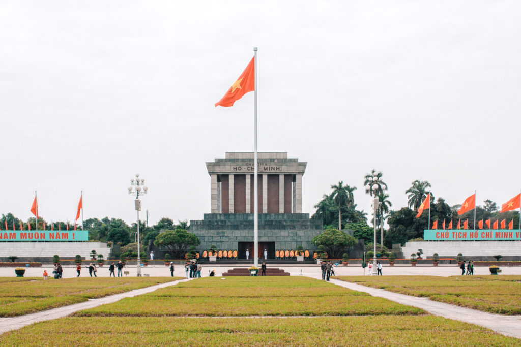 Ho Chi Minh Mausoleum, Hanoi, Vietnam. This is a photo of the front of the mausoleum. you can see gardens in front of it and a pole with the vietnamese flag.