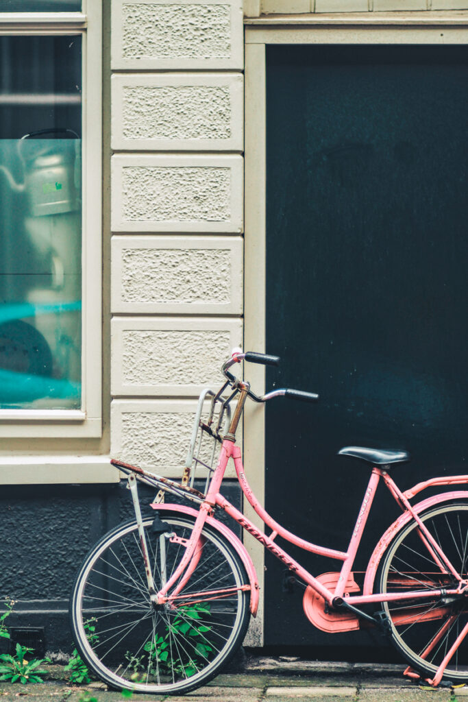 a pink bicycle against a house in Rotterdam, The Netherlands