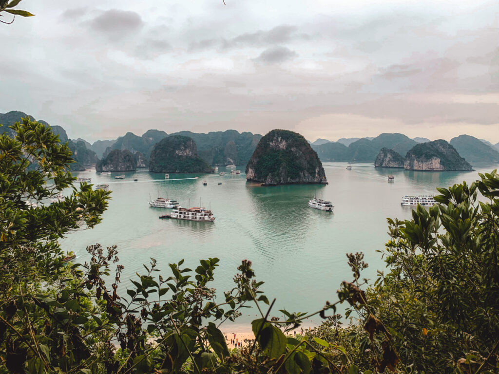 Halong Bay,Vietnam. In this photo, you can see karst mountains, surrounded by the ocean and boats or maneuvering in between them.