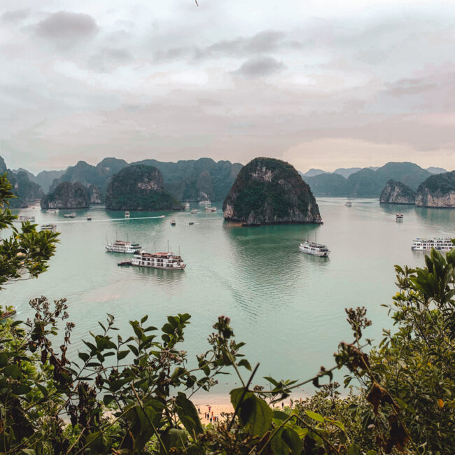 Halong Bay,Vietnam. In this photo, you can see karst mountains, surrounded by the ocean and boats or maneuvering in between them.