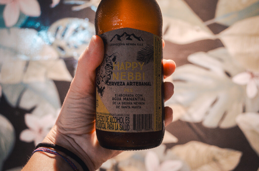 Craft beer from Cervecia Nevada, Minca, Colombia. This is a close-up from a hand holing a bottle.