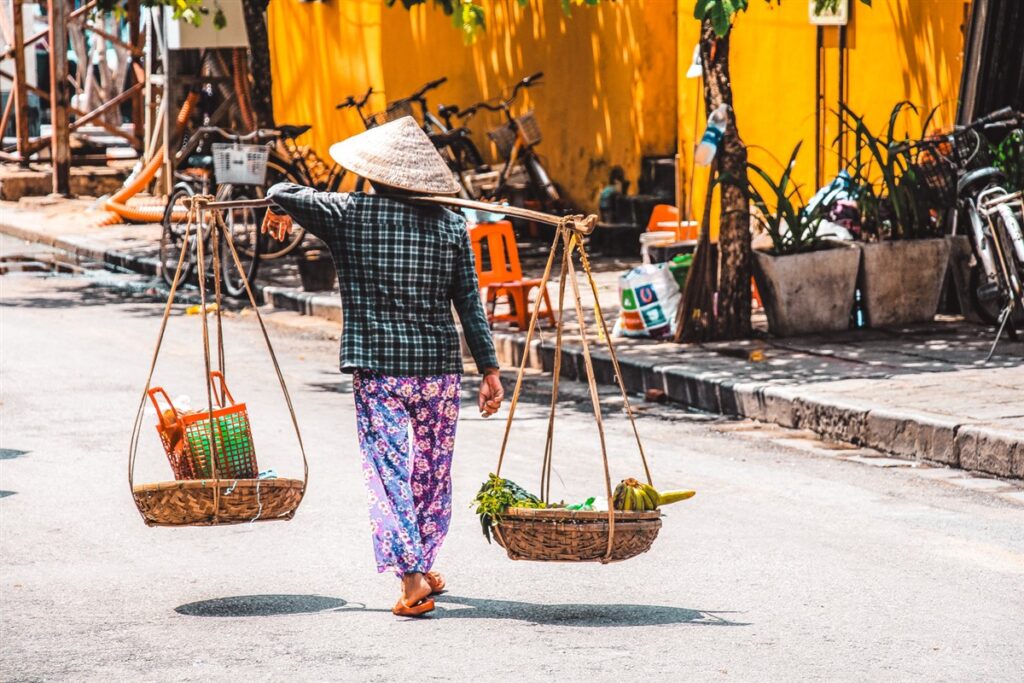 Hoi An, Vietnam- street vendors with traditional Vietnamese hats
