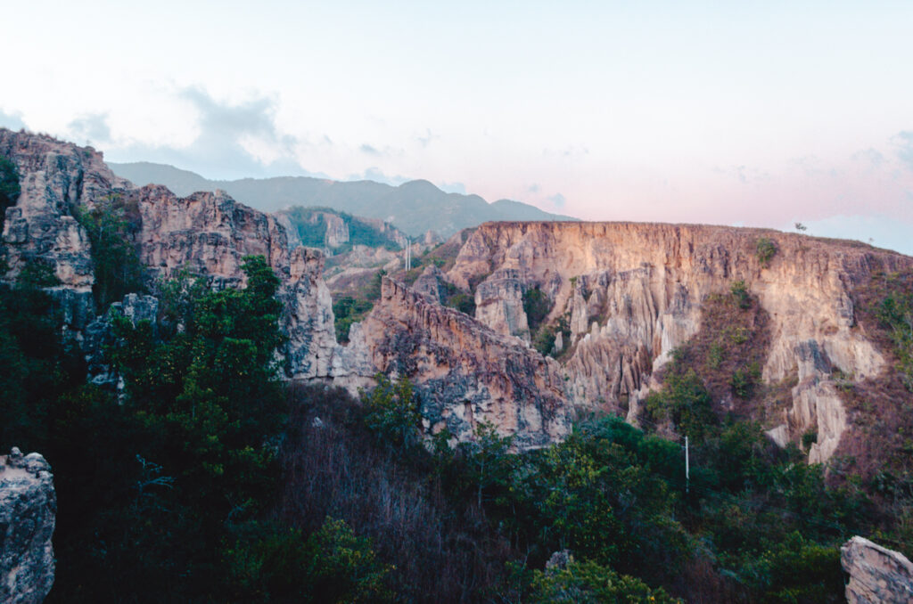 The majestic cliffs of a canyon in La Playa de Belen, Colombia, captured at twilight, with the fading light accentuating the rugged textures and vastness of the natural landscape.