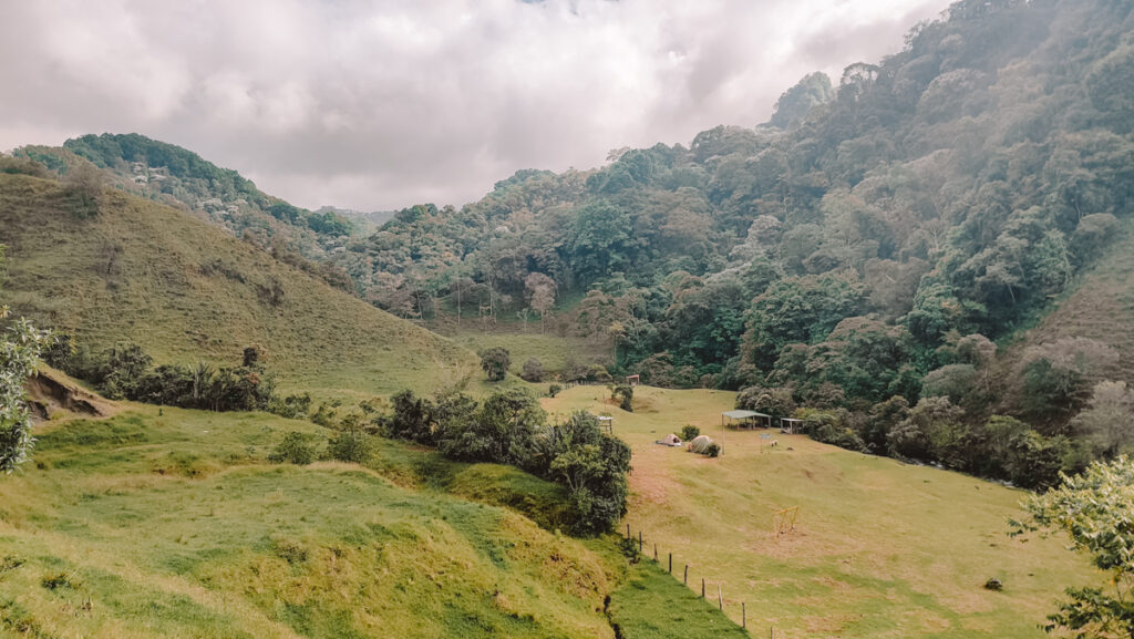Rolling hills and in the rural landscape of the Santa Rita waterfall near Salento, Colombia, showcasing the lush beauty of the region and a serene spot for nature walks and rural tourism.